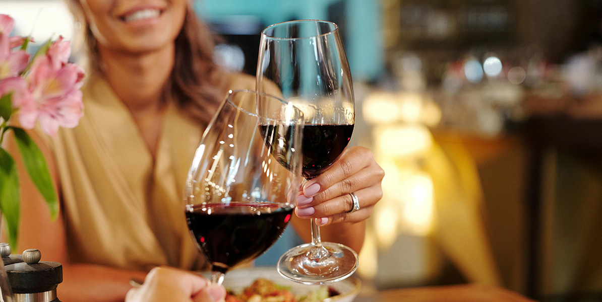 Detalle floral en la mesa junto a una copa de vino granadino.